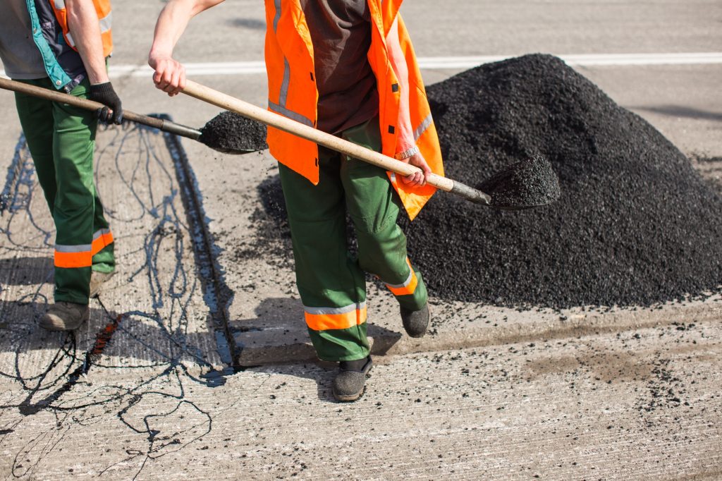 Repair of roads, highways and sidewalks. Patching. Working with a shovel falls asleep in the pit.